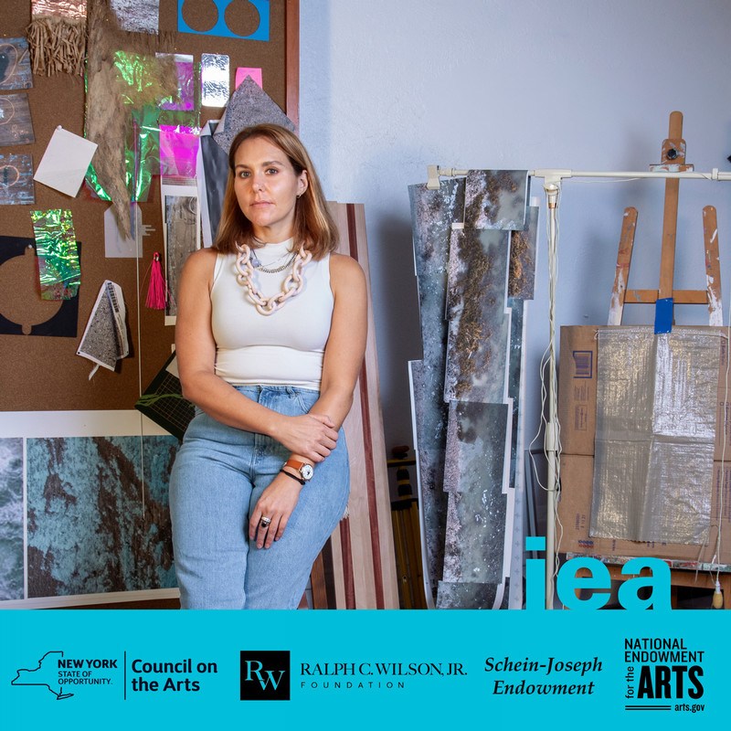 image of artist in studio surrounded by work