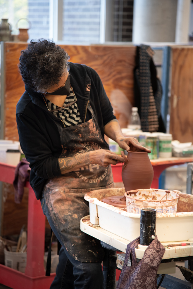 person working on a ceramic vase in the studio