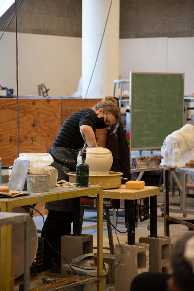 person working on ceramic vase in the studio