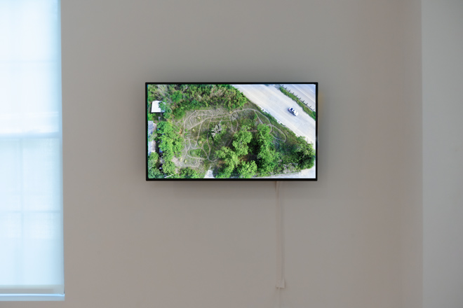 monitor hung on wall playing nature themed aerial shots
