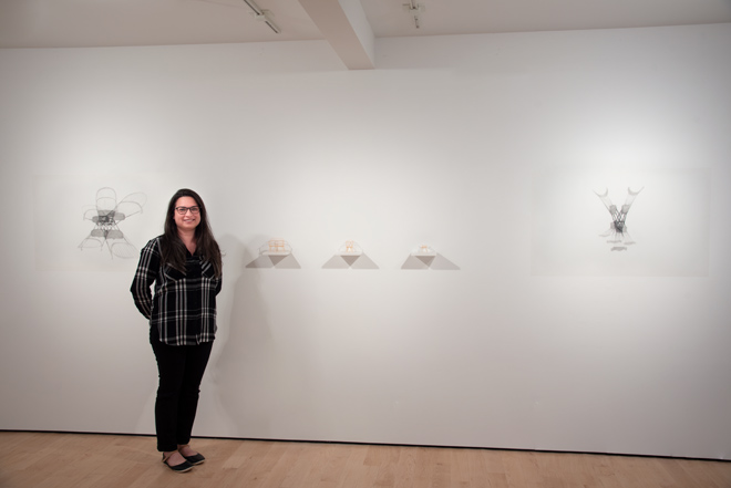 Rebecca standing next to her artwork on display