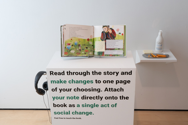 book propped up on a display with instructions for the viewer to make changes to the story