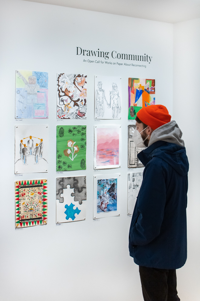 person in orange hat viewing the artwork on display