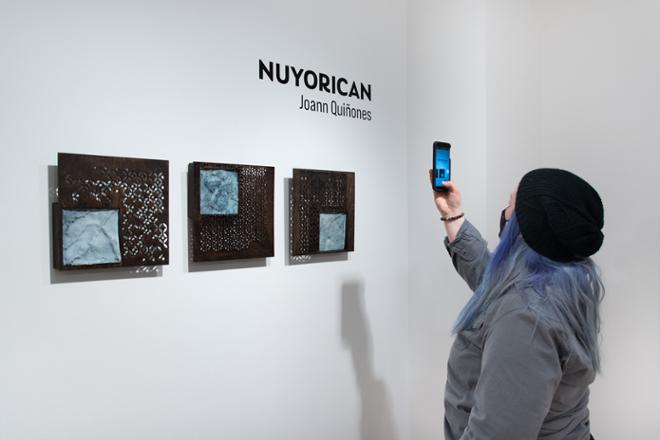 person taking a picture of artwork on their phone
