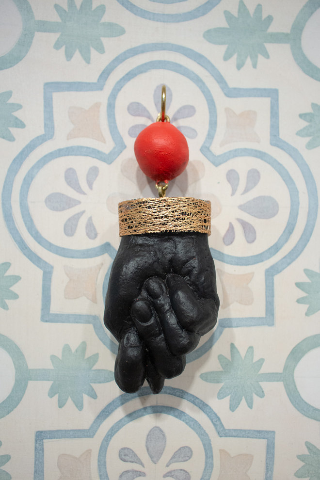detailed view of a red ball linked to a black hand