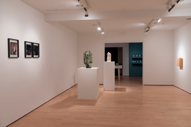 different corner of the gallery space with artwork on the wall and vases displayed