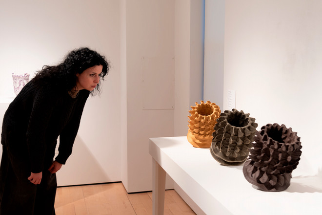 person looking at a set of vases