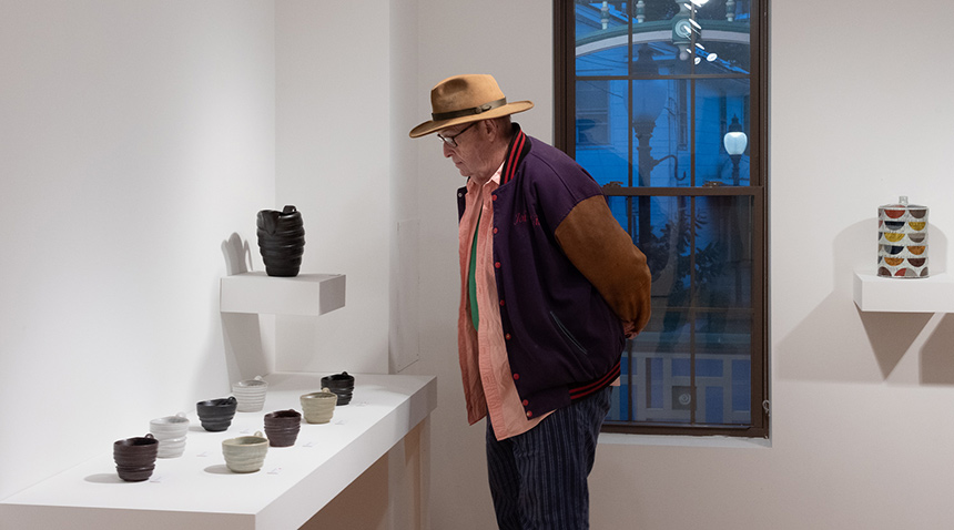 Man looking at pottery cups on display