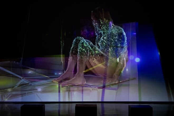 video projection still of human figure crouched with use of effects and multi-colors