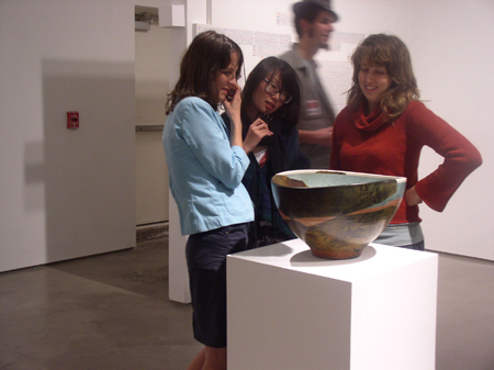 Three People Looking at The Bowl
