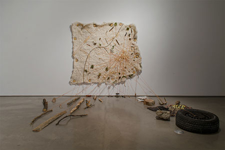 sculpture piece of cloth, wood, string and a car tire