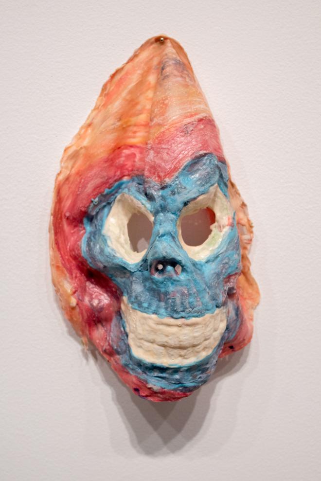 close-up of ceramic piece with bright paint and skull face shape