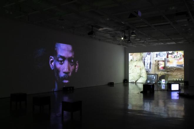 gallery space with video projection stills on the walls