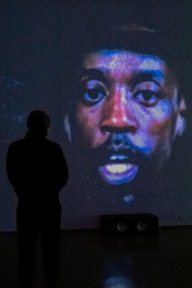Person observing video projection on gallery wall