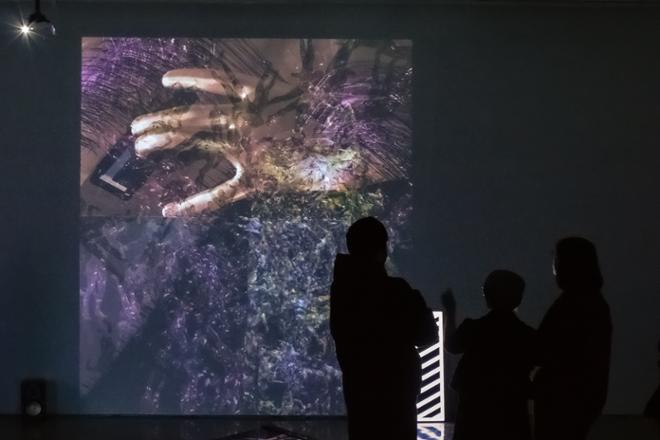 group of people observing video projection on wall