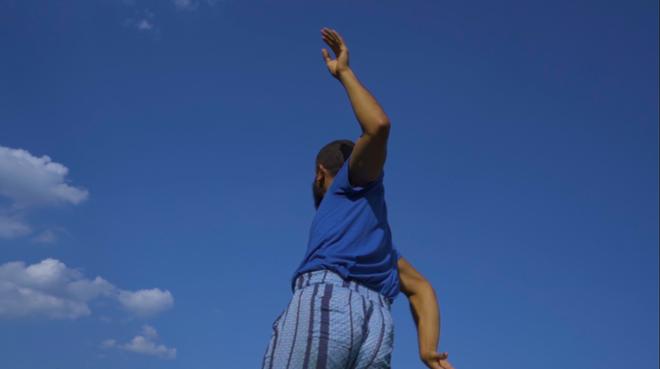 still image of person moving with angle pointed towards the blue sky
