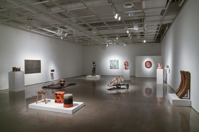 gallery space filled with various sculptures and wall art