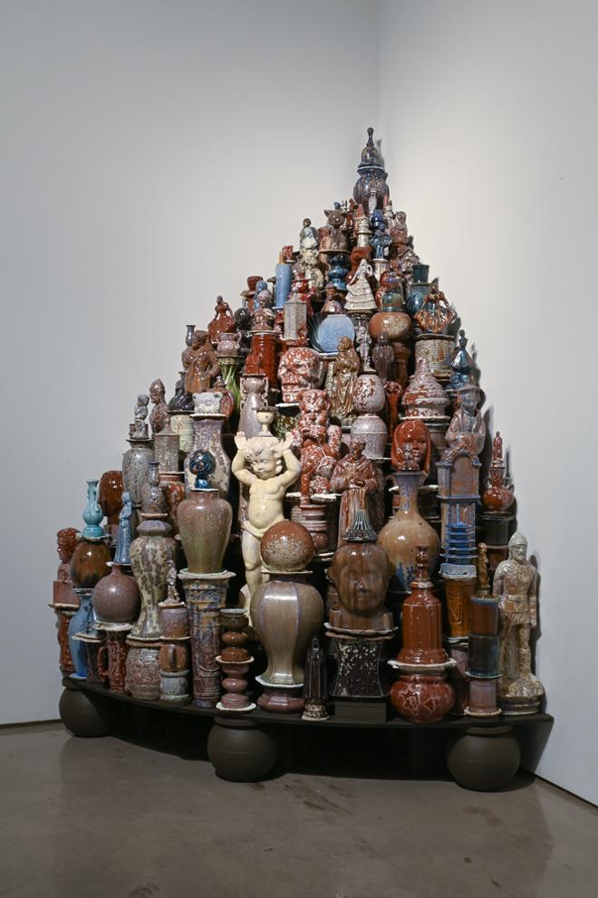 large group of figure sculptures and various sized ceramic pots and vases shaped to fit nicely in the corner
