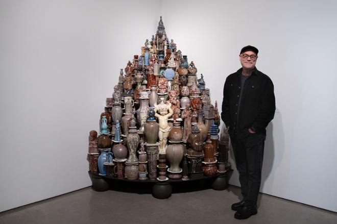 Walter McConnell posing with their corner sculpture of various figures, pots and vases