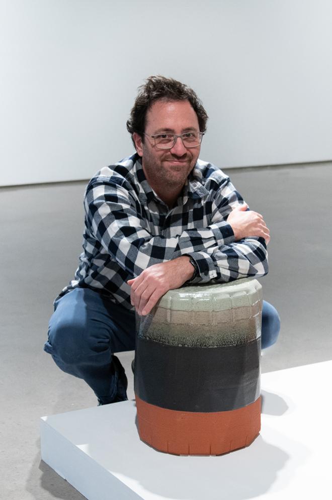 Johnathan Hopp posing with one of their side table or stool sculptures