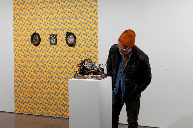 individual viewing a sculpture by Sharon Norwood