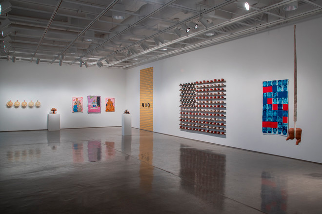 display of various art pieces on two walls in the gallery