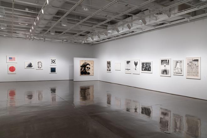 another corner of the gallery space filled with various prints