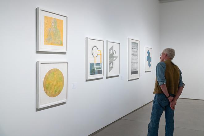person looking at some of the prints on display
