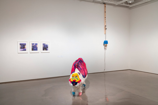 corner of gallery space with various sculptures on the wall and on the floor