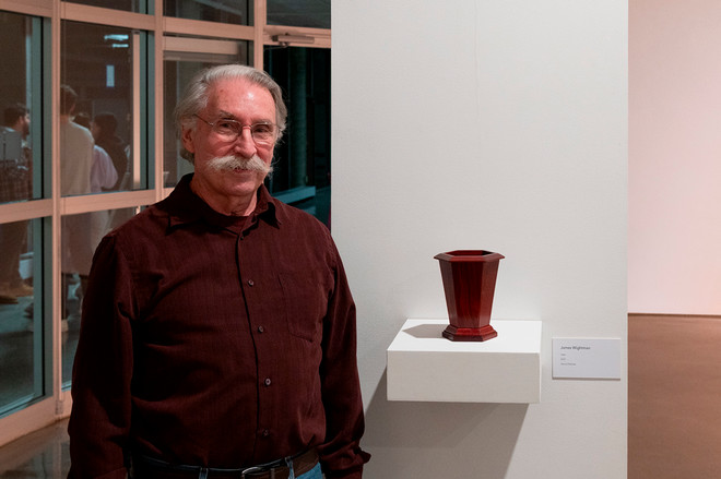 artist Jim posing next to a vase of theirs