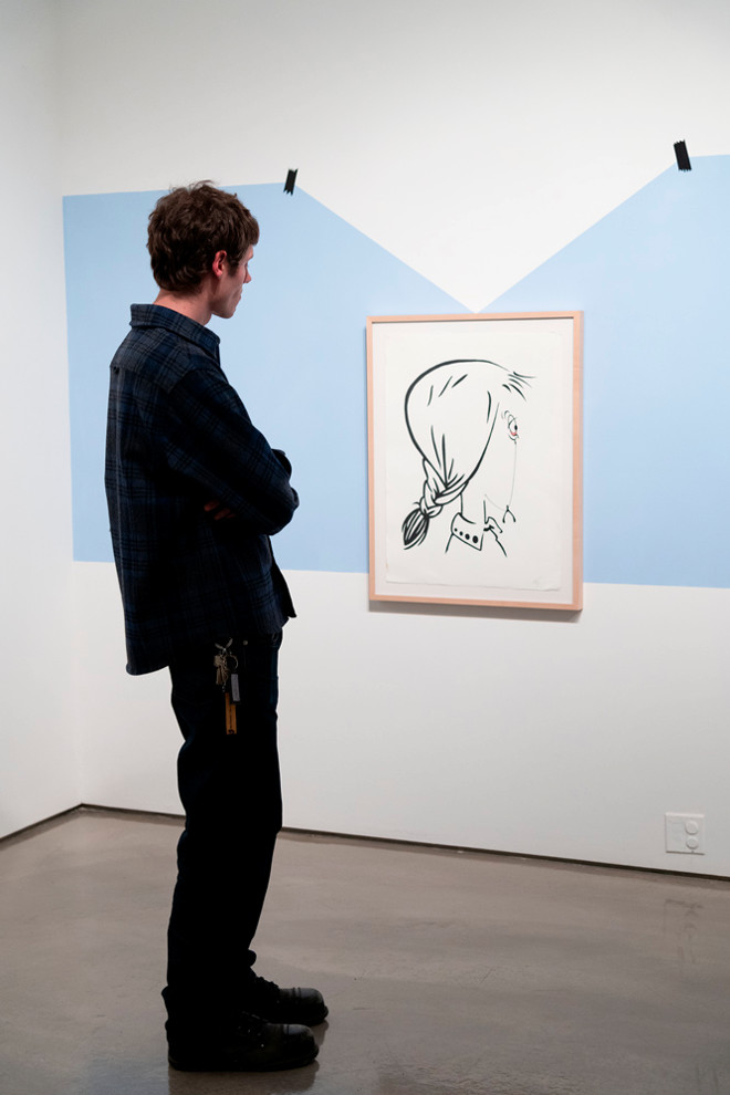 Person standing looking at a painting