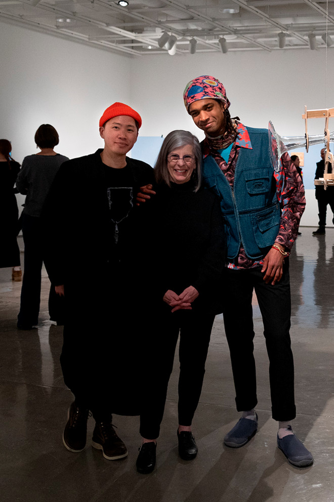 gallery director and artists posing with artwork