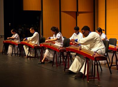 performance on stage of multiple people playing a Chinese Instrument