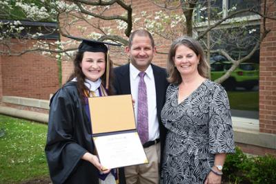 a graduate and her family smiling at camera