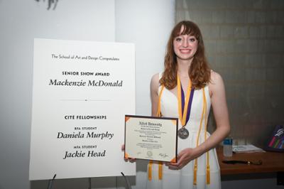 graduate holding diploma at graduation