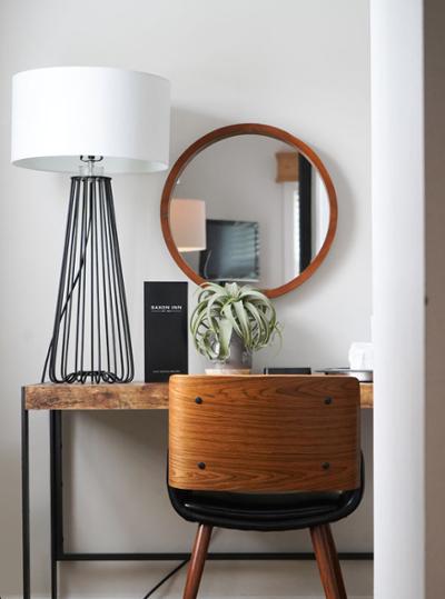 wooden side table, modern lamp, and mirror in room
