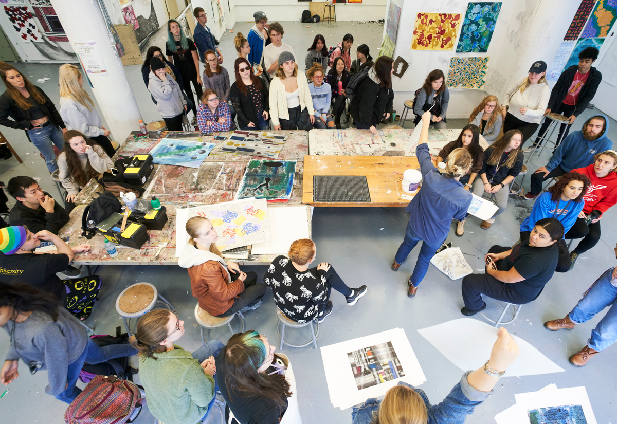 foundations class gathered around a table discussing works of art