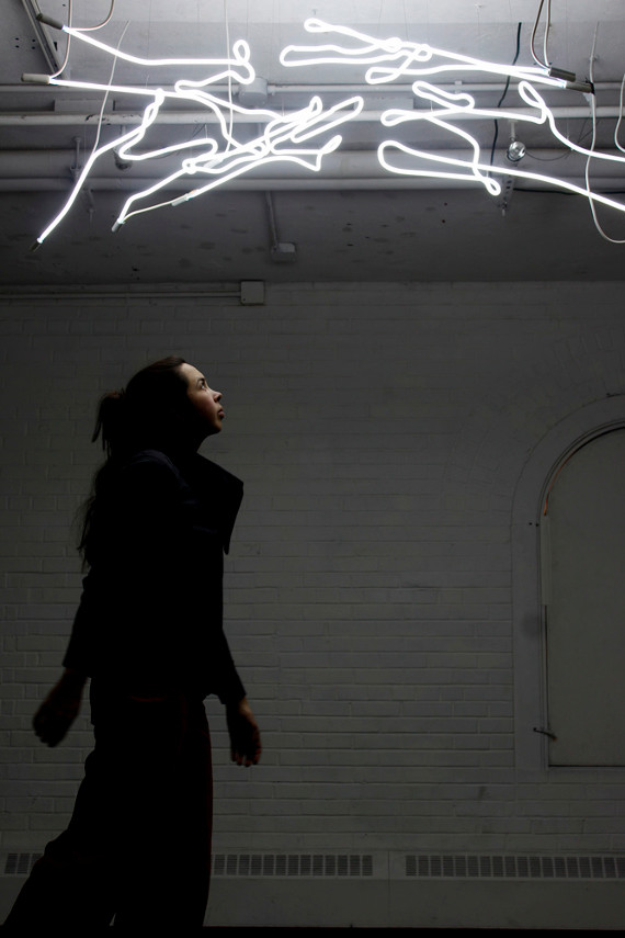 Woman walking under a canopy of neon lights