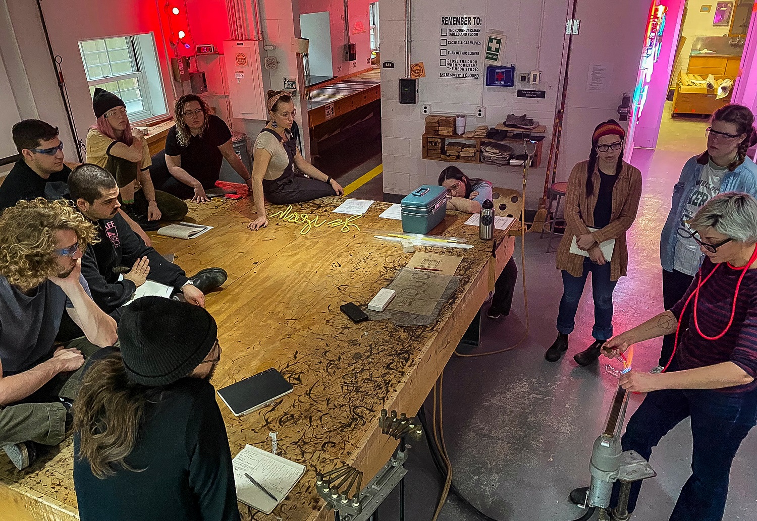 community members in the neon studio getting a demonstration