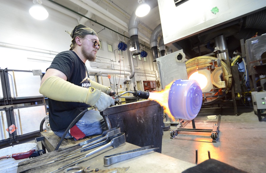 students in the hot shop working on blown glass pieces