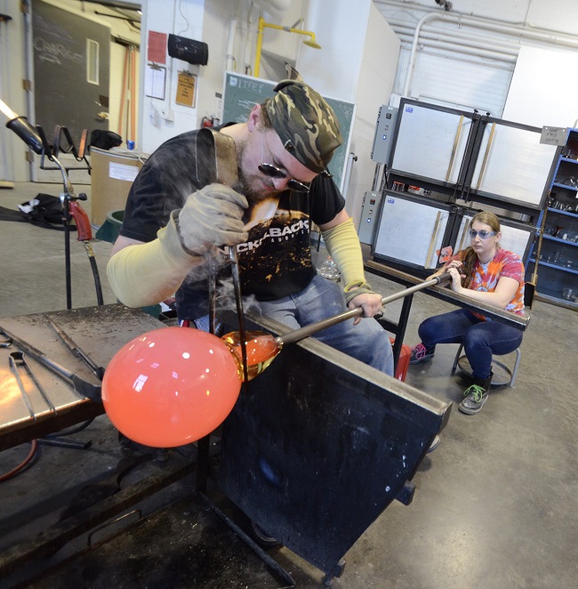 student clamping off a piece of glass from a pipe