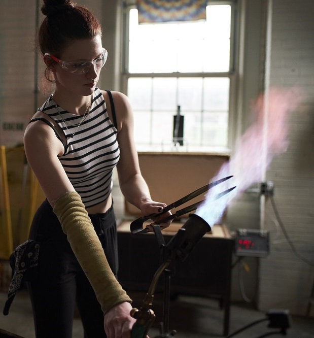 student torching glass