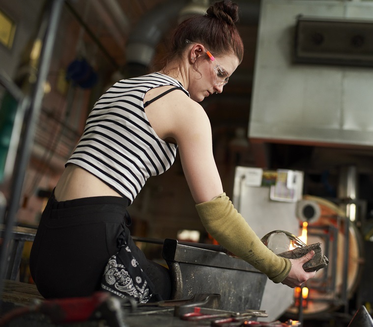 glass art student working with molten glass