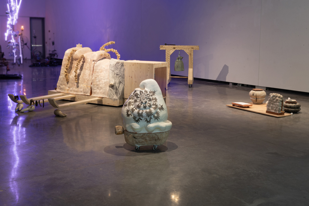 Abstract sculptures made from various materials in an open installation space.