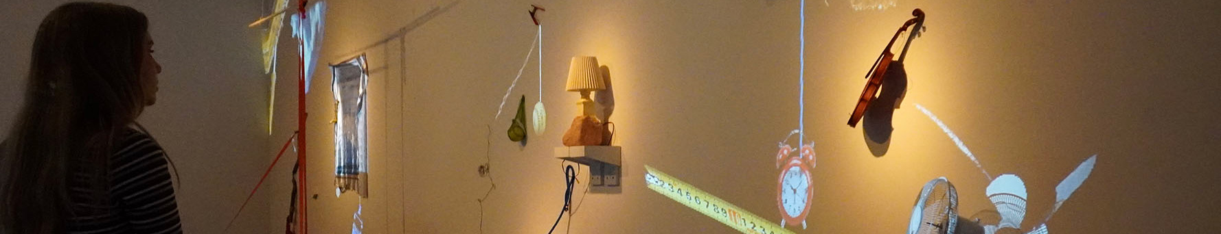 person looking at various objects on the wall with projections 