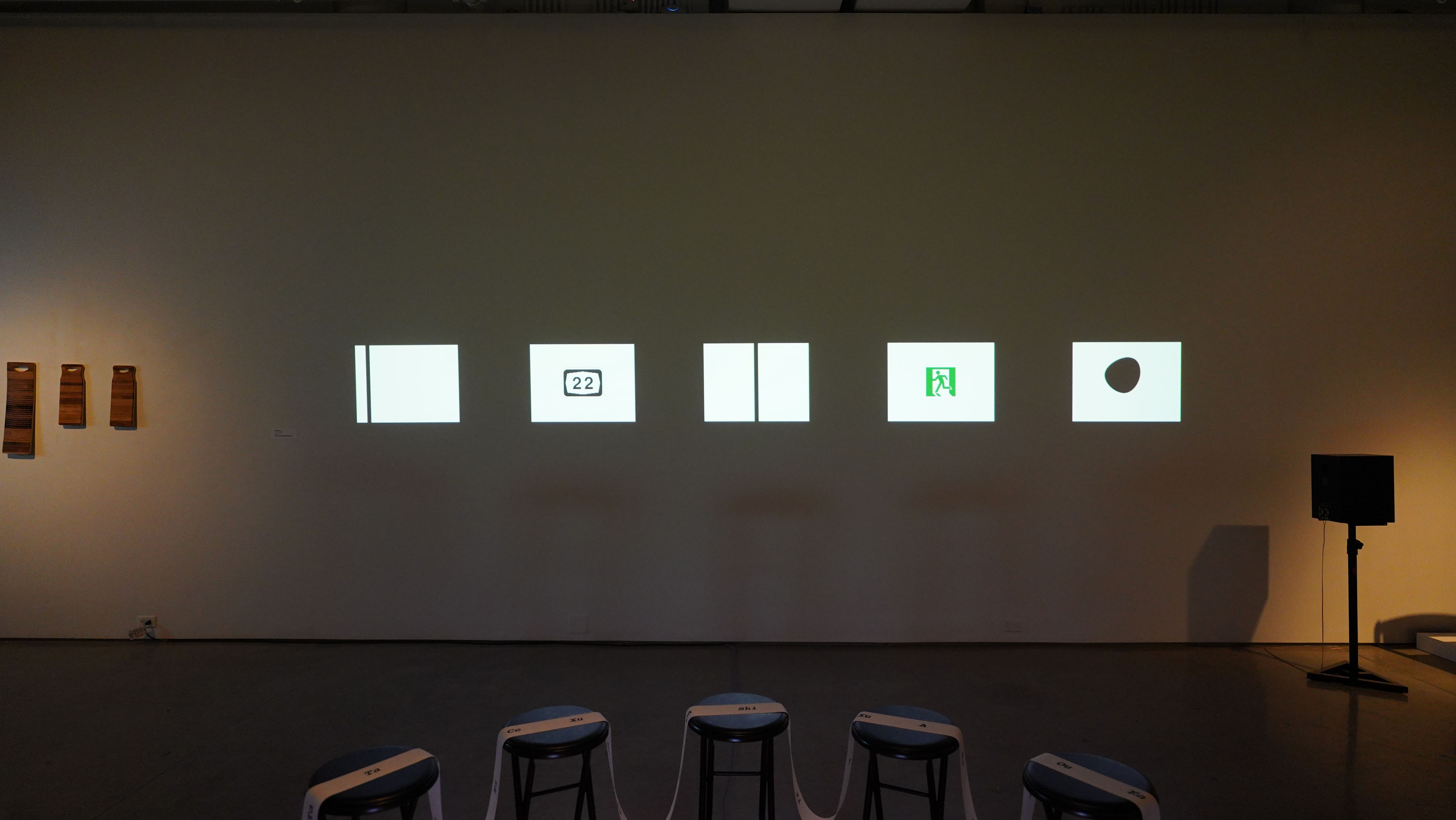 Wide gallery view with wall projections and seating installations.