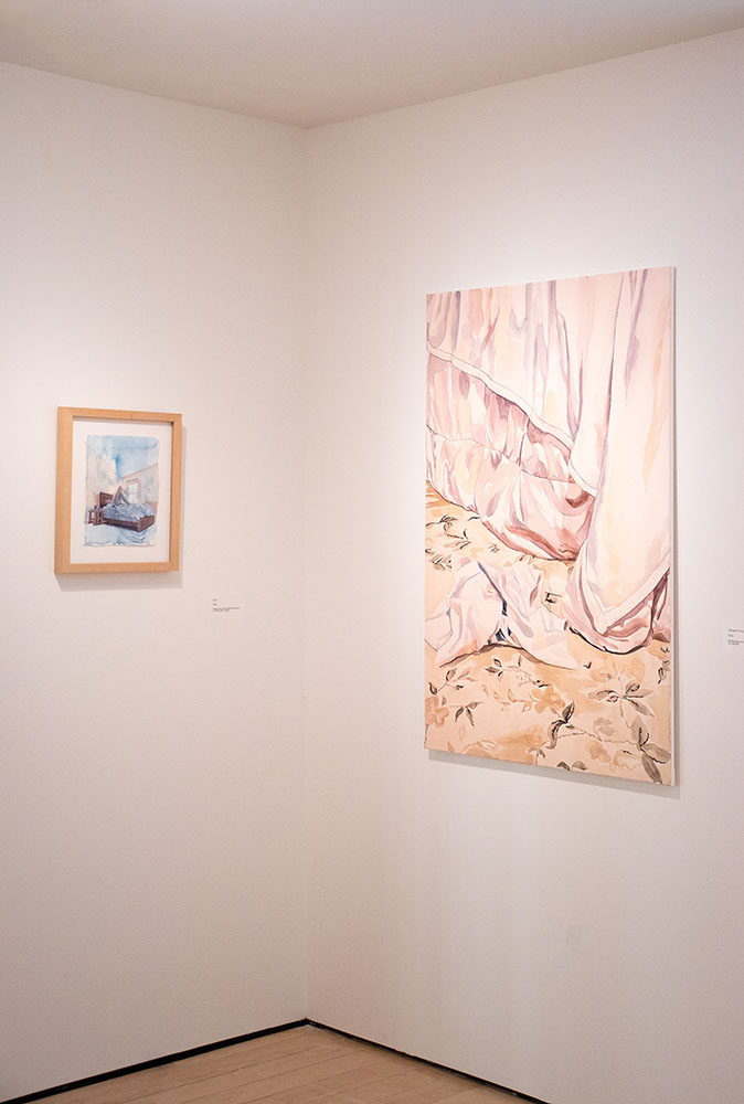 Gallery corner view with a small boat painting and a larger artwork of pink fabric over a floral surface.