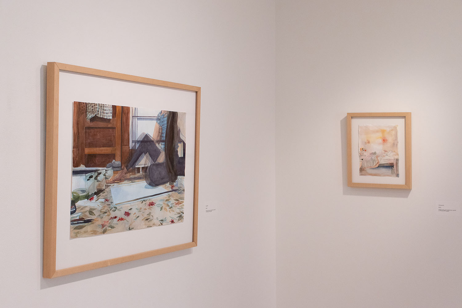 Two framed paintings: one of a cozy interior with plants and furniture, the other a soft abstract composition.