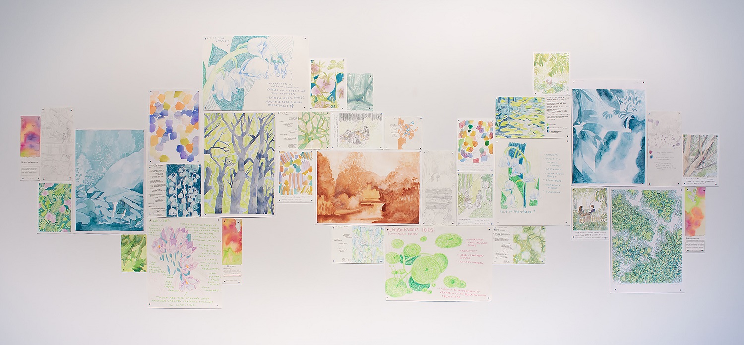 Wall collage of small artworks in various styles including landscapes and botanical illustrations