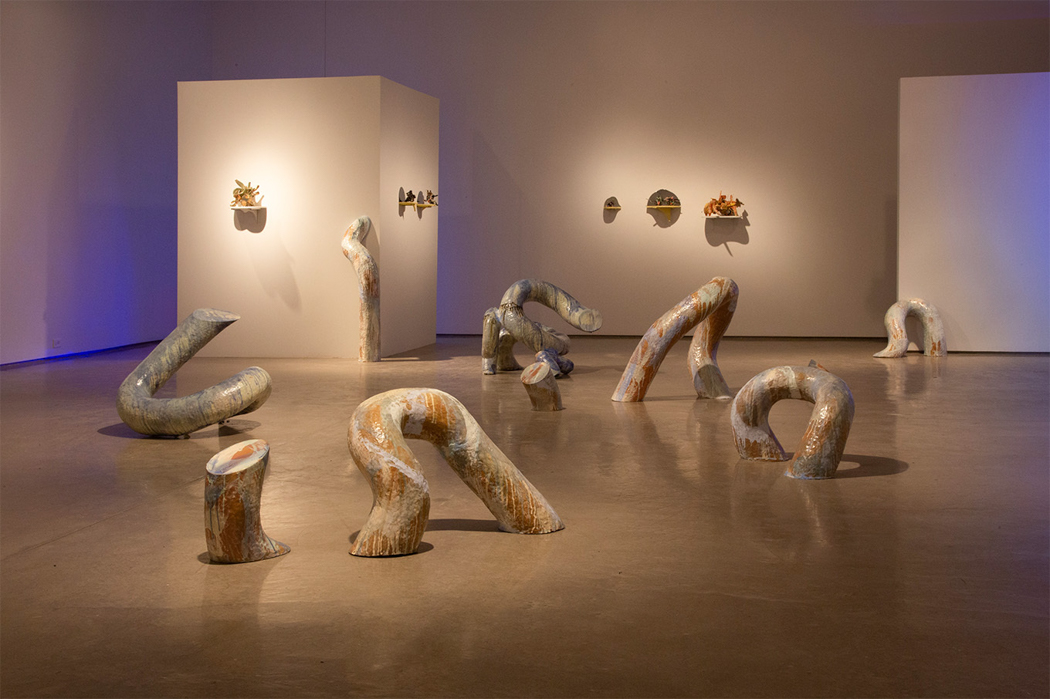 Large marbled ceramic tubes arranged on a gallery floor.